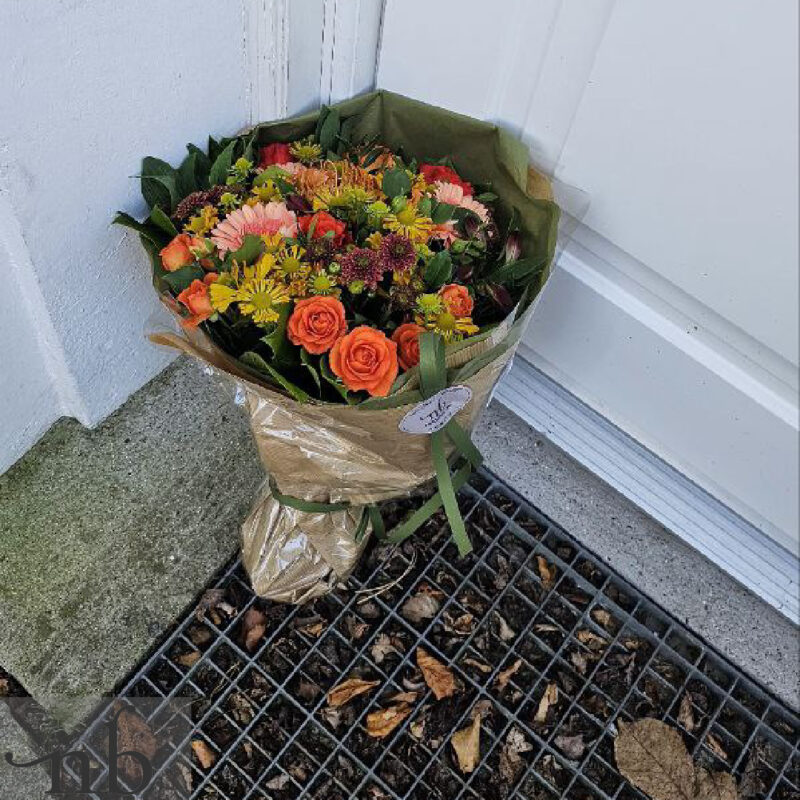 En glad mor modtager en frisk blomsterbuket med levering fra NetBuket på mors dag