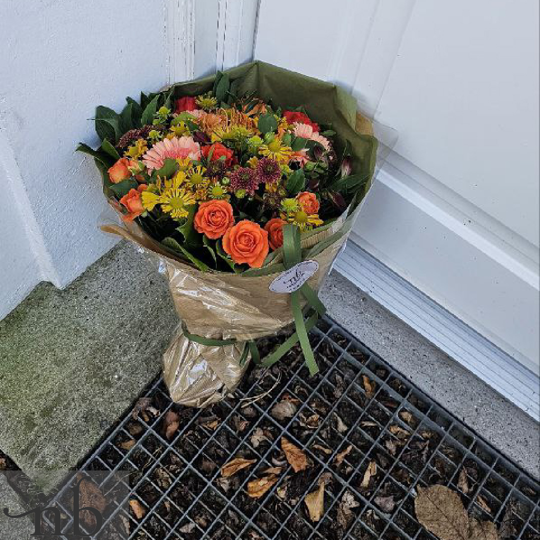En glad mor modtager en frisk blomsterbuket med levering fra NetBuket på mors dag