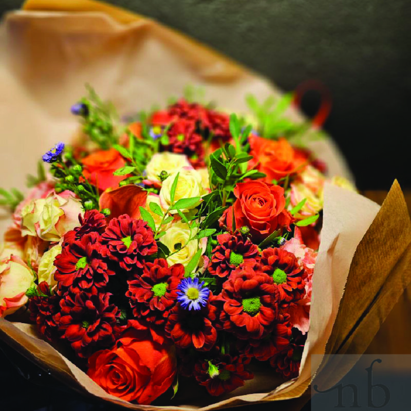 Halloween gavekurv med blomster i orange og lilla, delikatesser og sort bånd, leveret planlagt og sikkert