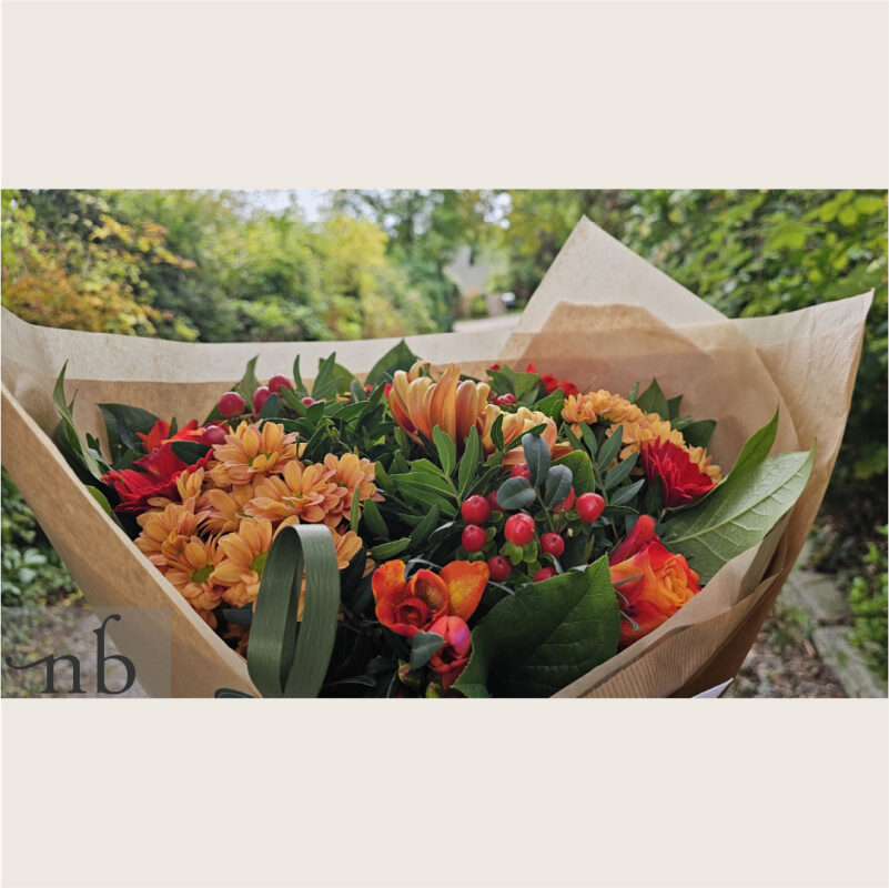 Halloween gavekurv med vin og chokolade i varm orange/lilla palette, pakket med bånd og leveret planlagt og sikkert