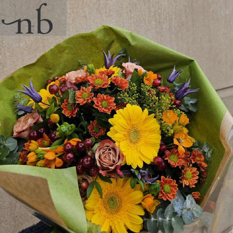 Græskar blomsterdekoration i orange og lilla med bær og grønt, leveret planlagt og sikkert